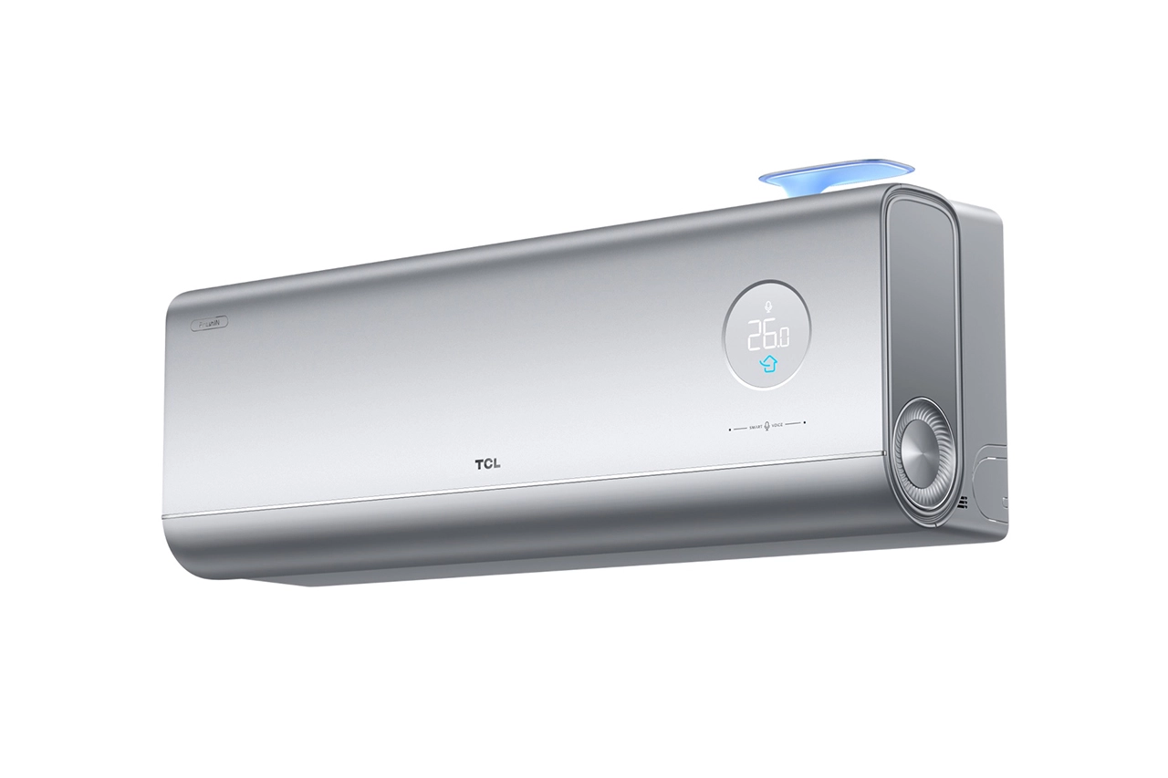 Kondicioner mural TCL FreshIN Series 3.0, ngjyrë argjendi metalike me dizajn futuristik, logo TCL në qendër, ekran rrethor LED që tregon 26.0°C me indikatorë Smart Voice, mekatronikë anësore me detaj rrethor dhe flap të sipërm me ndriçim blu për hyrjen e ajrit të pastër.